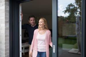 Glückliches Paar geht aus Schiebetür raus