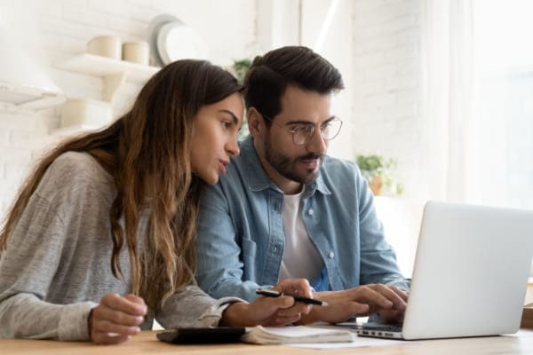 Paar sitzt vor Laptop, um günstige Fenster bei Fensterhandel online zu bestellen. Paar sitzt vor Laptop, um günstige Fenster bei Fensterhandel online zu bestellen.