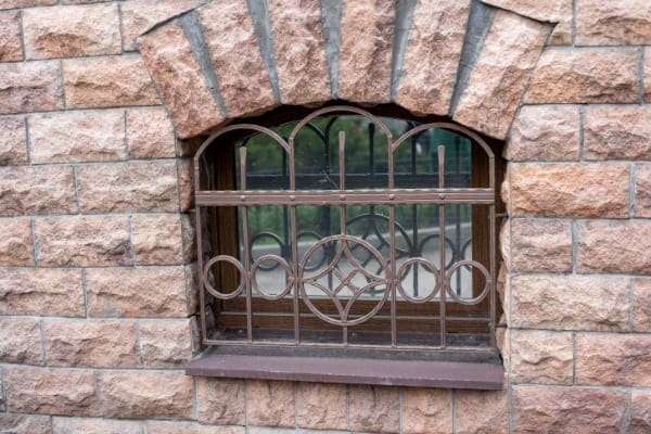 Kellerfenster mit Gitter an Straße.