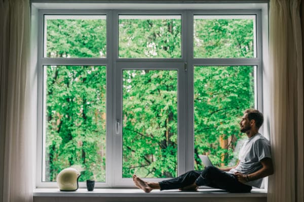 Mann schaut aus dem Glasfenster und genießt die Funktionen und den Ausblick