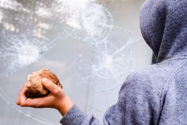Steinwerfer wirft große Steine auf Fenster mit hoher Widerstandsklasse