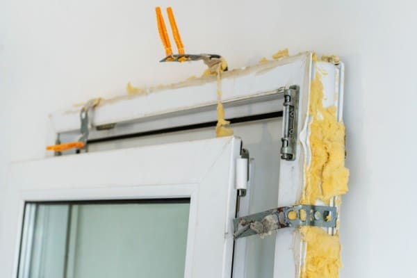 Bereits ausgebautes altes Fenster aus Kunststoff lehnt an der Wand