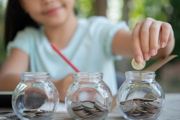 Kind wirft gespartes Geld in Glas