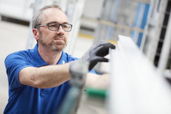 Monteur prüft Qualität der Fensterbeschläge Monteur prüft Qualität der Fensterbeschläge