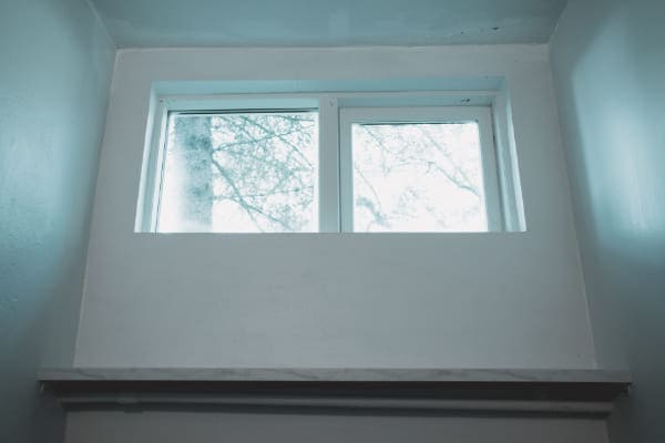 Kellerfenster mit Isolierverglasung im Winter.