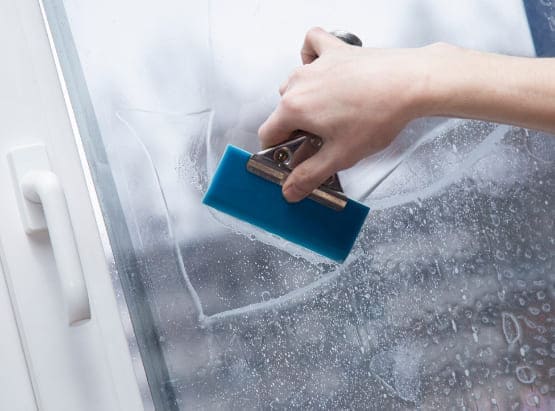 Schallschutzfolie wird mit Fensterschaber aus Kunststoff aufgebracht.