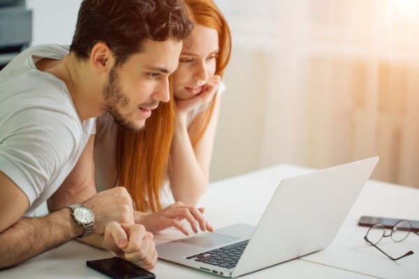 Paar konfiguriert ein modernes Fenster am Laptop