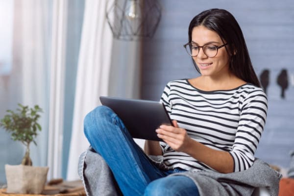 Frau an Tablet konfiguriert ein PVC Fenster im Konfigurator von fensterhandel.