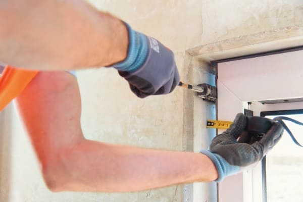 Fensterrahmen wird ausgerichtet mit Maßband und Hebel Fensterrahmen wird ausgerichtet mit Maßband und Hebel
