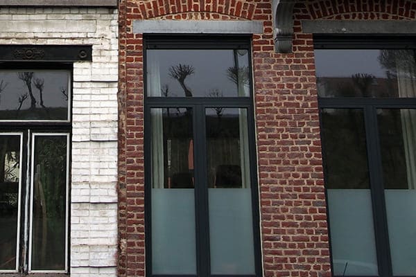 Denkmalschutzgebäude mit neuen Fenstern aus Kunststoff mit Aluminiumschale außen. Links sieht man noch ein Denkmalschutzgebäude mit alten Fenstern aus Holz. Denkmalschutzgebäude mit neuen Fenstern aus Kunststoff mit Aluminiumschale außen. Links sieht man noch ein Denkmalschutzgebäude mit alten Fenstern aus Holz.