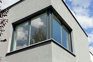 Anthrazit farbenes Eckfenster von außen gsehen im 1. Stock.