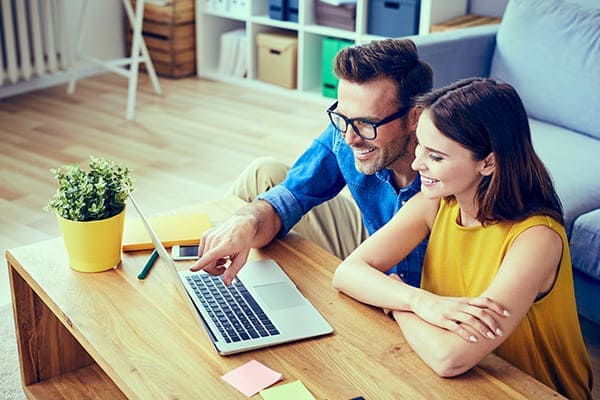 Glückliches paar kauft online mit Leptop ein.