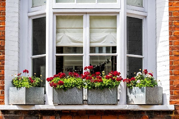 Altes Erkerfenster von außen mit Blumenkästen in Vordergrund.