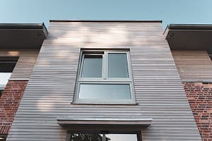 Haus von außen wo Fenster mit Unterlicht zu sehen sind.