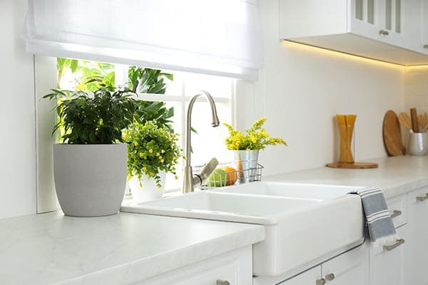 schöne helle Küche mit Fenster hinter der Spüle.