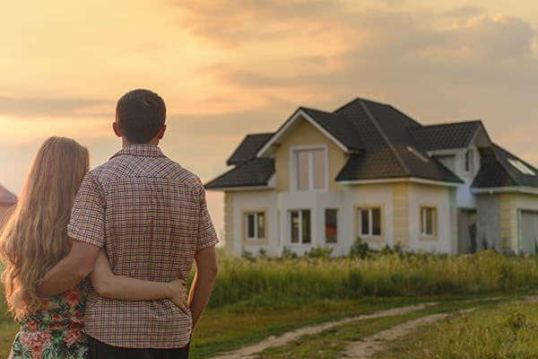 Ehepaar sehen sich Ihr Haus mit vielen verschiedenen Fenstertypen von außen an.