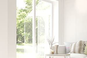 helles Wohnzimmer mit Couch und großem Fenster.