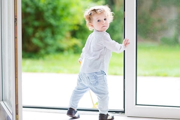 Kind geht durch offenes Fenster
