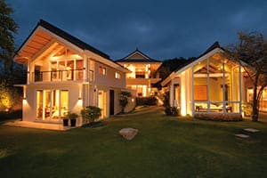 Villa super schön beleutet in der Nacht mit großen Fensterflächen.