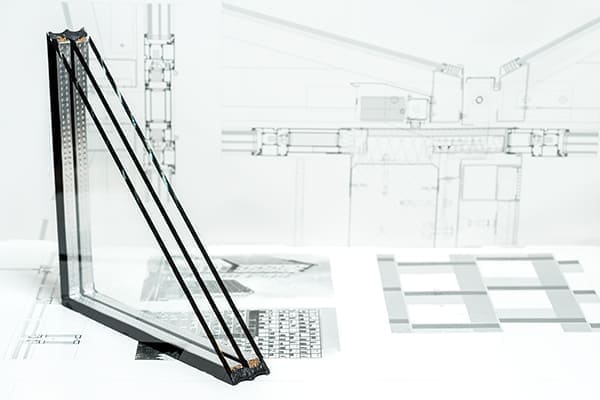 Dreifachglas mit Bauzeichung im Hintergrund. Dreifachglas mit Bauzeichung im Hintergrund.