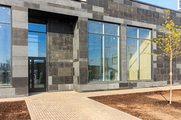 graues Gebäude mit neuen Glasscheiben von außen gesehen  graues Gebäude mit neuen Glasscheiben von außen gesehen