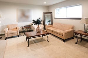 Wohnzimmer im Keller mit schönem Kellerfenster in weiß.