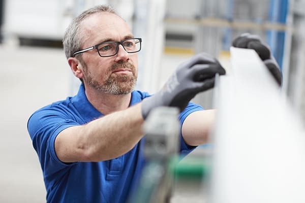 Produkthalle mit Mitarbeiter der Profil ausmisst.