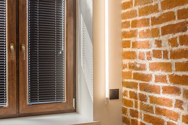 Braunes Kunststofffenster von innen gesehen mit schwarzen Jalousien. Braunes Kunststofffenster von innen gesehen mit schwarzen Jalousien.