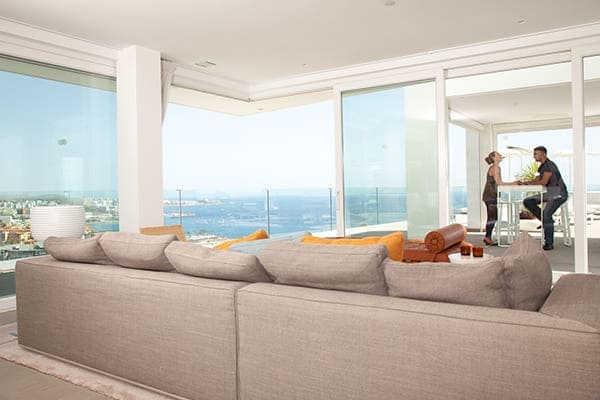 Großes Wohnzimmer mit Panoramafenstern und Ausblick aufs Meer.