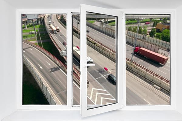 Weißes Fenster im Hintergrund ist eine stark befahrene Autobahn zu sehen.