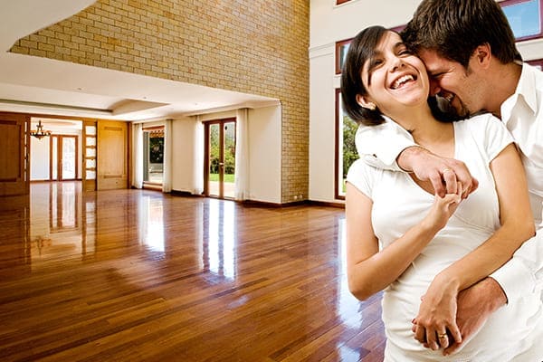 Junges glückliches Paar im neuen Haus mit Schallschutzfenstern.