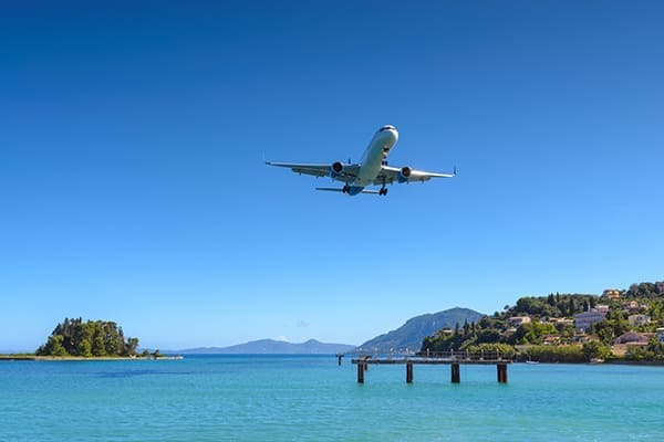 Flugzeugt fliegt an Häusern vorbei in der nähe von Korfu. Flugzeugt fliegt an Häusern vorbei in der nähe von Korfu.