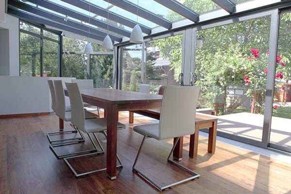 Modernes Esszimmer als Wintergarten mit schönen hellen Schallgeschützen Fensterelementen. Modernes Esszimmer als Wintergarten mit schönen hellen Schallgeschützen Fensterelementen.