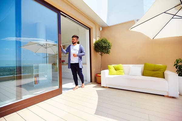 Mann schiebt den großen Fensterflügel zur seite auf. Mann schiebt den großen Fensterflügel zur seite auf.