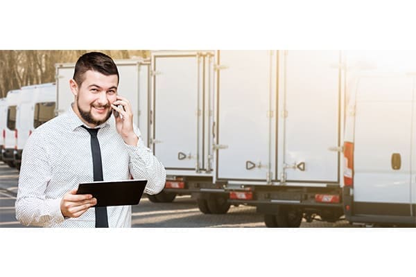 Manager mit digitalem Tablet und Telefon im Hintergrund Lkw's. Manager mit digitalem Tablet und Telefon im Hintergrund Lkw's.