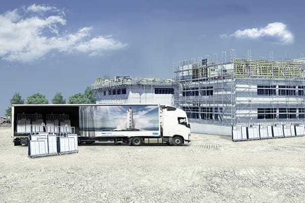 Feba Fensterbau LKW mit Rohbau im Hintergrund.