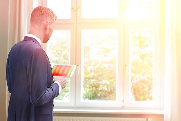 Geschäftsmann steht für Fenster mit Wärmebildkamera auf seinem Talett Geschäftsmann steht für Fenster mit Wärmebildkamera auf seinem Talett