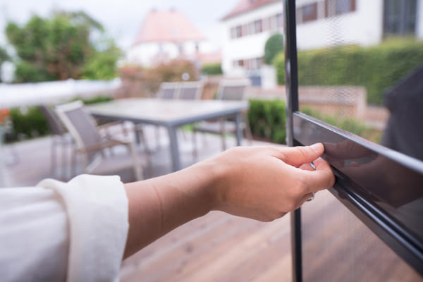 Insektenschutztür wird von einer Person geöffnet