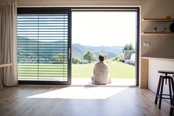 Frau sitz auf der Terrassentür ohne Schwelle und relaxed mit einer Tasse Kaffee