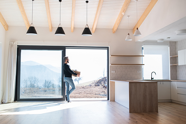 Mann geht nach draußen über Terrassentür ohne Schwelle mit einer Moving Box