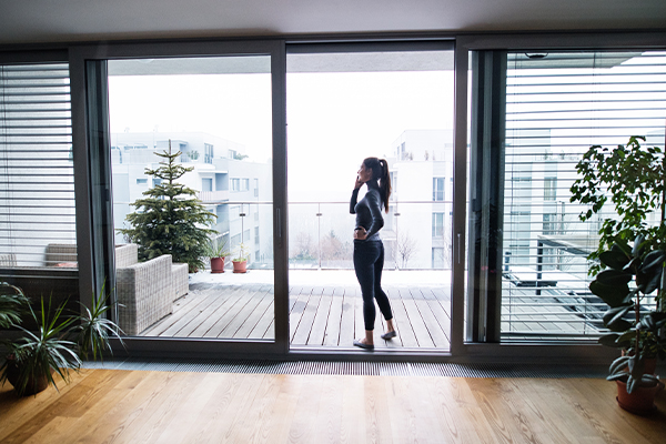 Frau geht über Terrassentür ohne Schwelle mit ihrem Samrtphone am Ohr